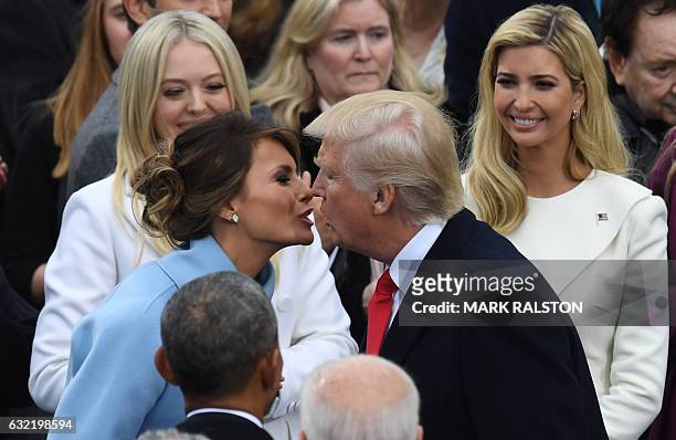 President-elect Donald Trump kisses his wife Melania before his swearing in ceremony on January 20, 2017 at the US Capitol in Washington, DC. / AFP /...