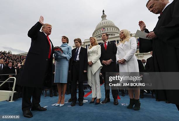 President Donald Trump takes the oath of office as his wife Melania holds the bible and his children Barron, Ivanka, Eric and Tiffany watch as US...