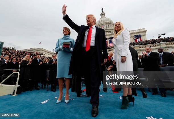 President Donald Trump acknowledges the audience after taking the oath of office as his wife Melania and daughter Tiffany watch during inauguration...