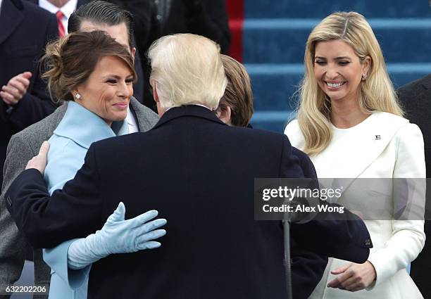 President Donald Trump embraces First Lady Melania Trump as daughter Ivanka Trump looks on after his inauguration on the West Front of the U.S....