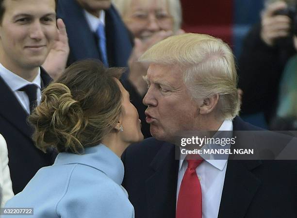 President-elect Donald Trump kisses is wife Melania as he arrives on the platform at the US Capitol in Washington, DC, on January 20 for his...