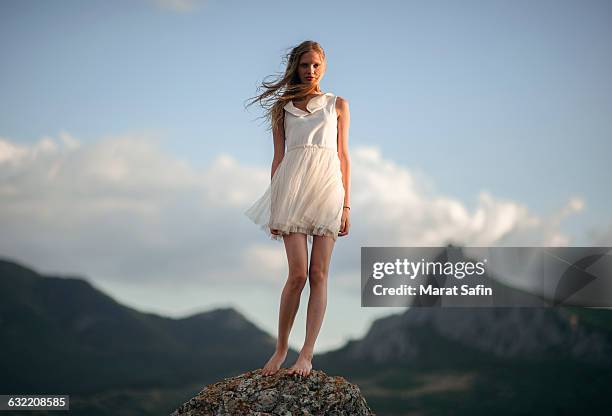 caucasian woman standing on remote hilltop - donne bionde scalze foto e immagini stock