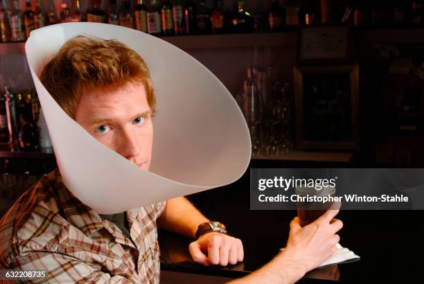 man wearing medical cone in bar - chocolate bar foto e immagini stock