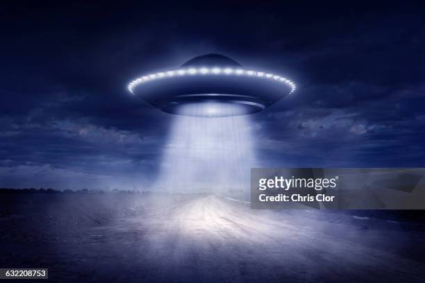 alien spaceship landing on rural road - flying saucer stock illustrations