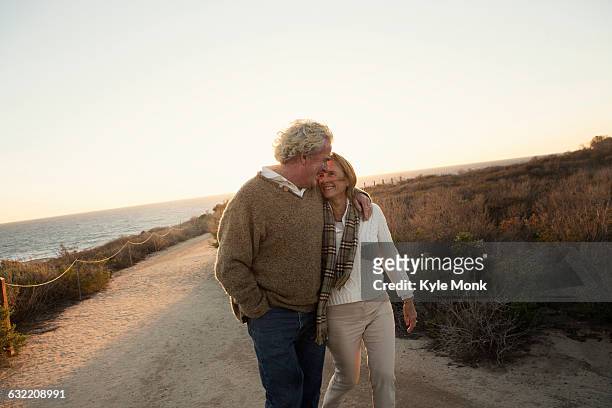 older caucasian couple walking on dirt path - romantic holiday stock-fotos und bilder