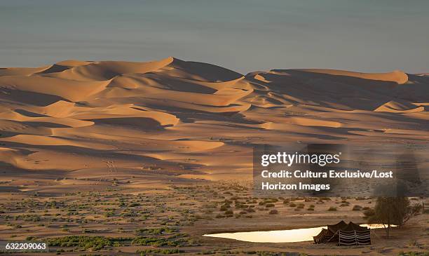 bedouin tent and giant sand dunes in the empty quarter desert, between saudi arabia and abu dhabi, uae - bedouin tent stock pictures, royalty-free photos & images