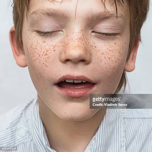 close up of caucasian boy with freckles - mouth thinking stockfoto's en -beelden