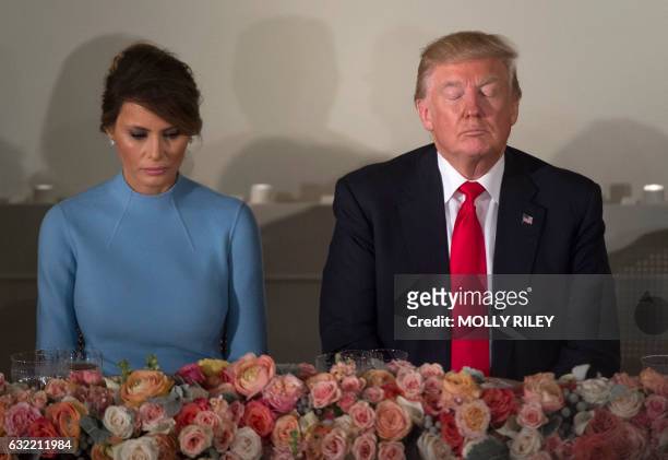 President Donald Trump and First Lady Melania Trump pray during the Inaugural Luncheon at the US Capitol following Donald Trump's inauguration as the...