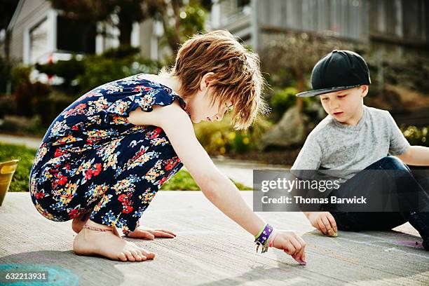 siblings drawing with chalk on sidewalk - barefoot redhead ストックフォトと画像