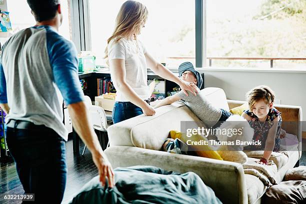 family relaxing together in living room of home - seattle homes stock pictures, royalty-free photos & images
