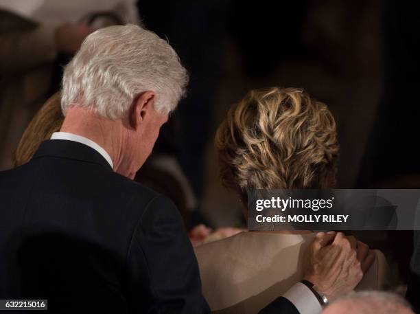 Former US President Bill Clinton and Hillary Clinton bow their heads in prayer during the Inaugural Luncheon in Statuary Hall in the US Capitol...