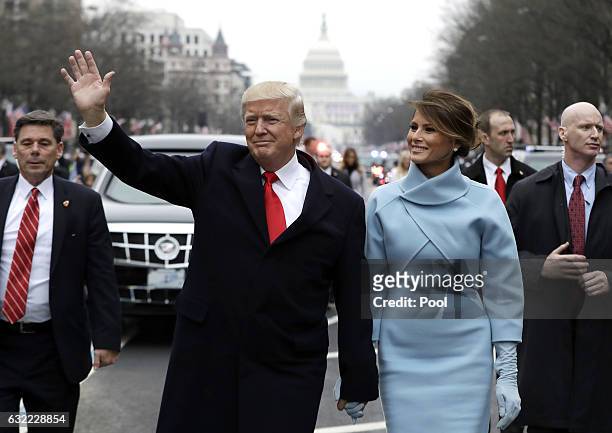 President Donald Trump waves to supporters as he walks the parade route with first lady Melania Trump after being sworn in at the 58th Presidential...