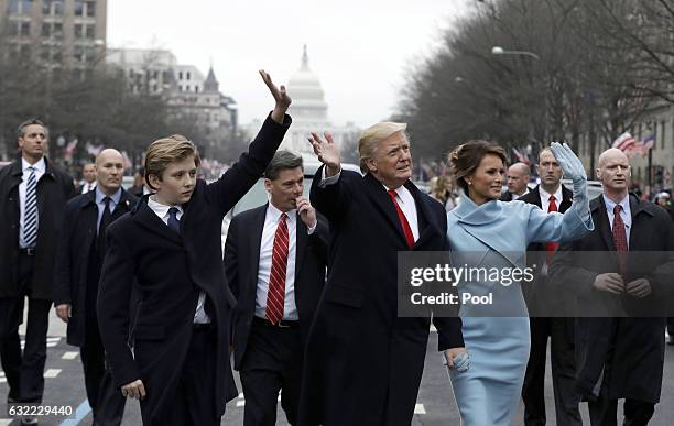 President Donald Trump waves to supporters as he walks the parade route with first lady Melania Trump and son Barron Trump after being sworn in at...