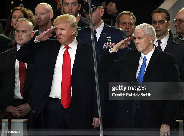 President Donald Trump and Vice President Mike Pence salute during the Inaugural Parade from the main reviewing stand in front of the White House on...