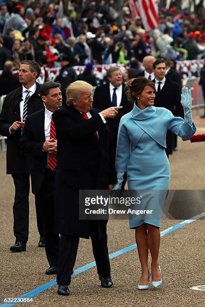 President Donald Trump waves to supporters as he walks the parade route with first lady Melania Trump during the Inaugural Parade on January 20, 2017...