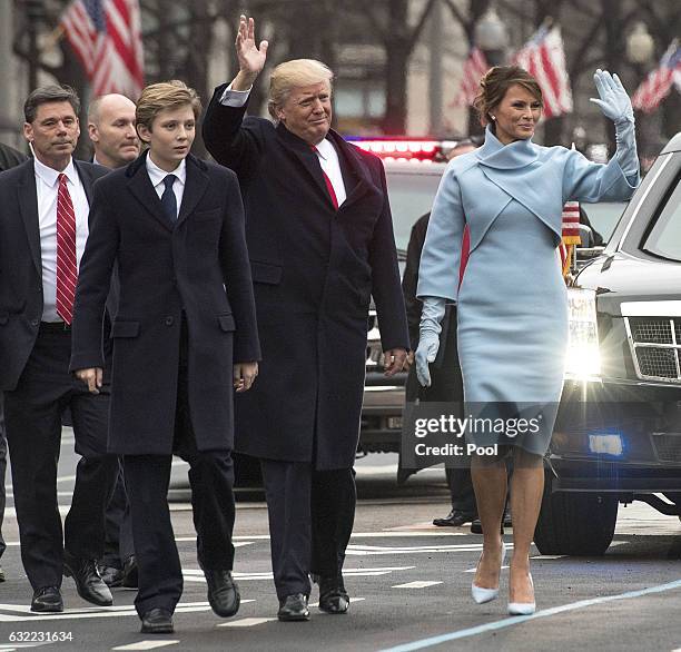 President Donald Trump and first lady Melania Trump, along with their son Barron, walk in their inaugural parade on January 20, 2017 in Washington,...