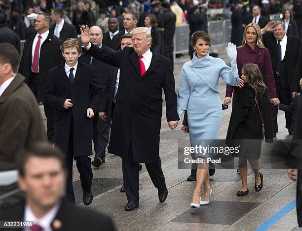 President Donald Trump and first lady Melania Trump, along with their son Barron, walk in their inaugural parade on January 20, 2017 in Washington,...