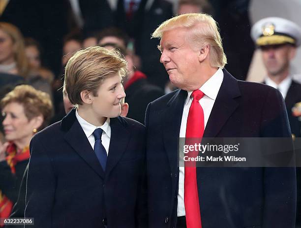 President Donald Trump stands with his son Barron Trump inside of the inaugural parade reviewing stand in front of the White House on January 20,...