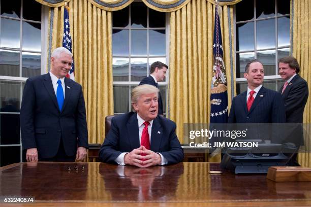 President Donald Trump speaks to the press as he waits at his desk before signing conformations for General James Mattis as US Secretary of Defense...