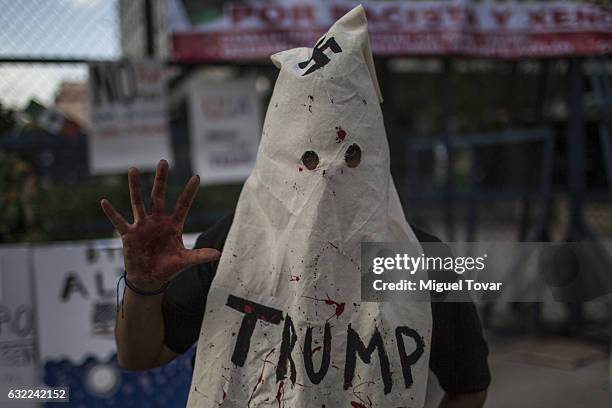 Protesters wears a hooded Ku Klux Klan mask during protest against US President Elect Donald Trump after being sworn in at Mexican US Embassy on...