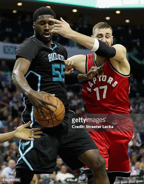 Roy Hibbert of the Charlotte Hornets and Jonas Valanciunas of the Toronto Raptors go after a loose ball during their game at Spectrum Center on...