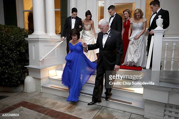 Vice President Mike Pence helps his wife Karen Pence down the steps of the front porch of the vice presidential residence at the U.S Naval...