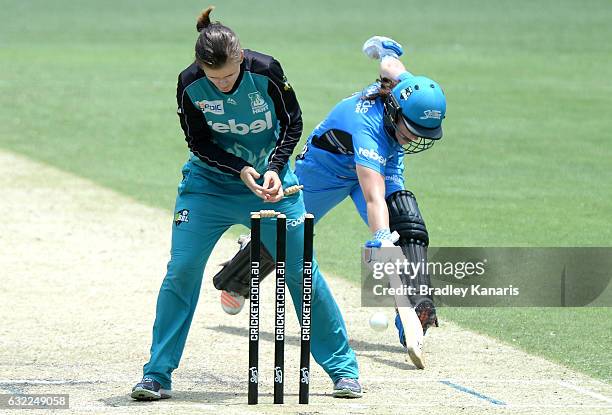 Tegan McPharlin of the Strikers is caught short of her ground by Jessica Jonassen of the Heat during the Women's Big Bash League match between the...