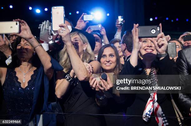 Guests take pictures and watch US President Donald Trump and First Lady Melania dance during the Freedom ball at the Walter E. Washington Convention...