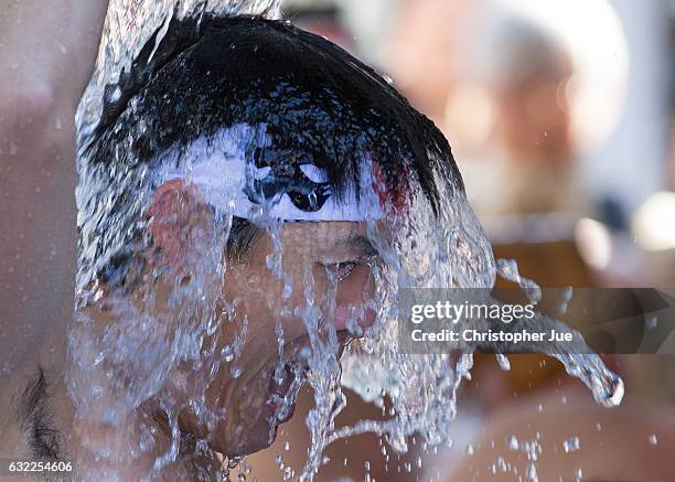 Participant splashes ice-cold water on himself during the ice water winter purification ceremony on January 21, 2017 in Tokyo, Japan. At Daikoku...