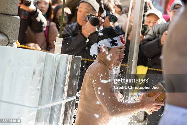 Participant splashes ice-cold water on himself during the ice water winter purification ceremony on January 21, 2017 in Tokyo, Japan. At Daikoku...