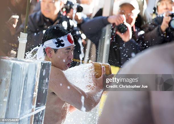 Participant splashes ice-cold water on himself during the ice water winter purification ceremony on January 21, 2017 in Tokyo, Japan. At Daikoku...