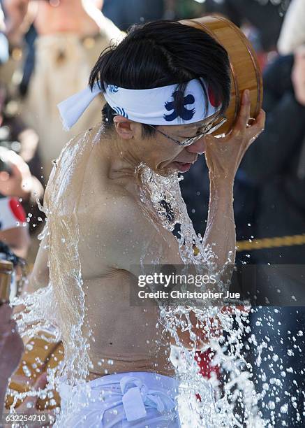 Participant splashes ice-cold water on himself during the ice water winter purification ceremony on January 21, 2017 in Tokyo, Japan. At Daikoku...