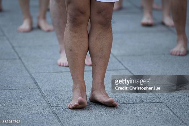 Participant's feet is seen reacting to the cold weather prior to the start of the ice water winter purification ceremony on January 21, 2017 in...