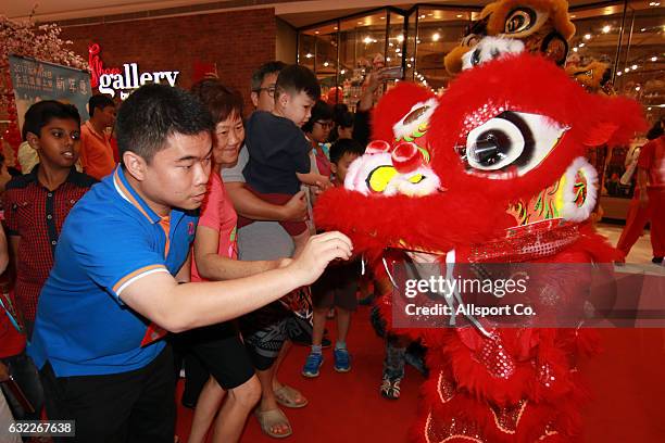 People greets the lion dancer during meet and greet by the lion dance troupe at a mall ahead of the Lunar New Year of the Rooster celebrations on...