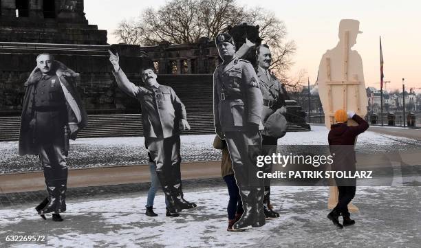 Demonstrators carry cardboard cut-outs depicting Spanish dictator Francisco Franco, Soviet dictator Joseph Stalin, Italian dictator Benito Mussolini...