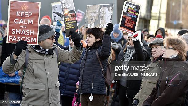 Participant of a Women's March in Helsinki holds up a poster depicting US President Donald Trump and German dictator Adolf Hitler on January 21 one...