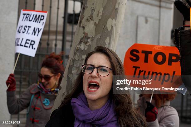 Women shouts slogans as demonstrators hold placards reading 'Trum, 42 ST. NY Killer.' and 'Stop Trump' during a demonstration in front of the US...