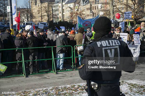 German policeman wearing riot gear stands guard as crowds gather behind barriers to protest against a Europe of Nations and Freedom meeting in...