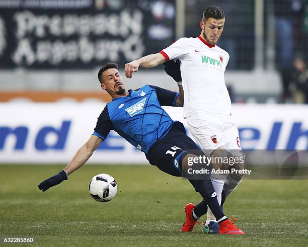 Sandro Wagner of 1899 Hoffenheim tackles Jeffrey Gouweleeuw of Augsburg during the Bundesliga match between FC Augsburg and TSG 1899 Hoffenheim at...