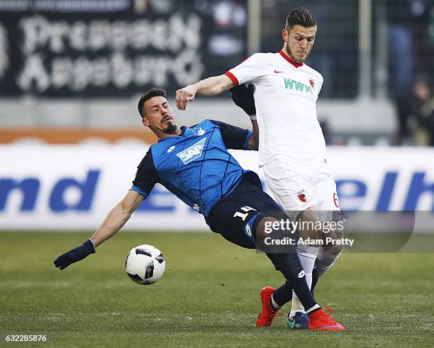 Sandro Wagner of 1899 Hoffenheim tackles Jeffrey Gouweleeuw of Augsburg during the Bundesliga match between FC Augsburg and TSG 1899 Hoffenheim at...