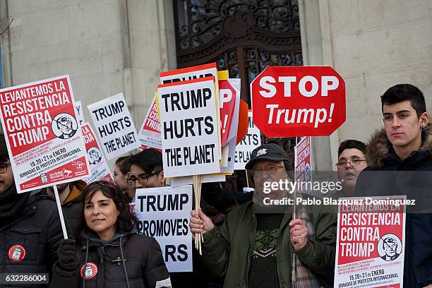 Demonstrators hold placards reading 'Let's lift the resistance against Trump', 'Trump hurts the planet', 'Trump promotes wars' and 'Stop Trump'...