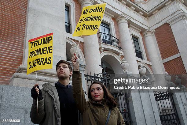 Demonstrators hold placards reading 'Trump promotes wars' and 'Nor hate, nor racism, neither Trump.' during a demonstration in front of the US...