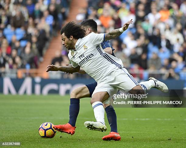 Real Madrid's Brazilian defender Marcelo vies with Malaga's midfielder Juanpi during the Spanish league football match Real Madrid CF vs Malaga CF at...