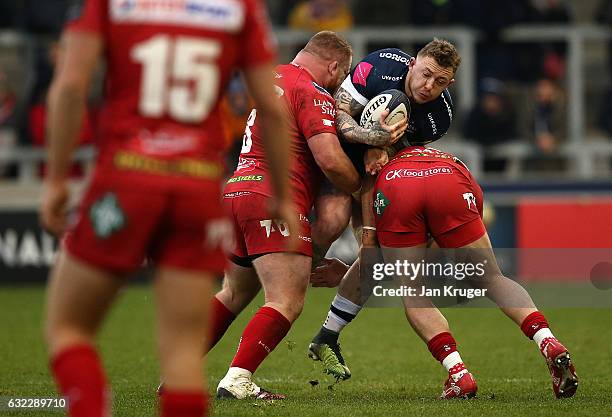 Josh Charnley of Sale Sharks is tackled by Samson Lee of Scarlets during the European Rugby Champions Cup match between Sale Sharks and Scarlets at...