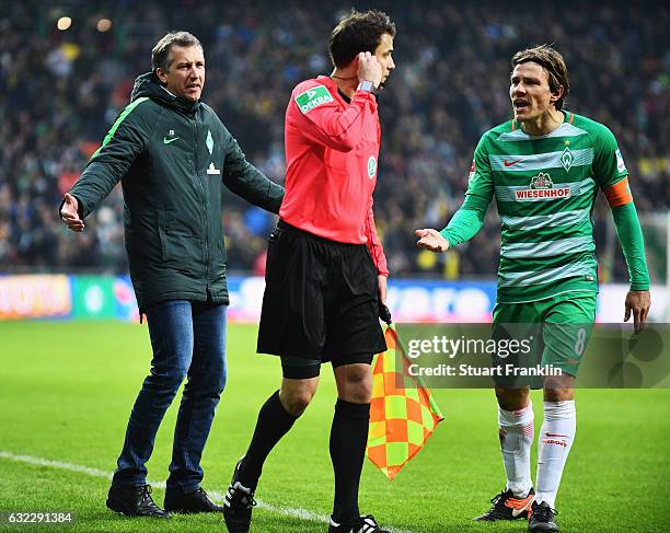 Clemens Fritz and Frank Baumann, sports director of Bremen appeal to the referees assistant after the red card during the Bundesliga match between...