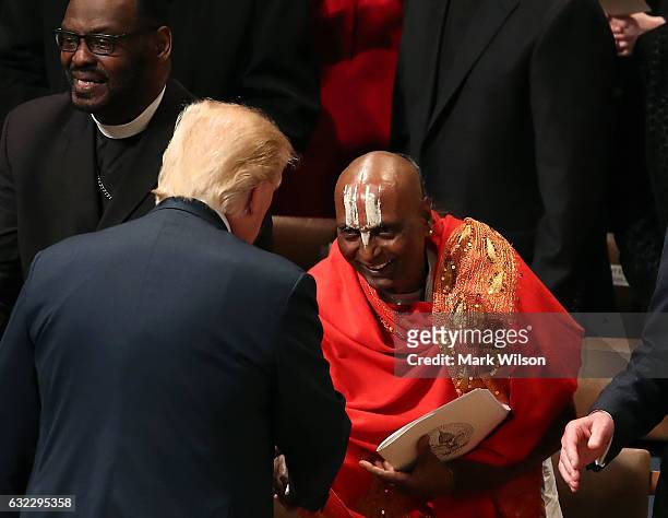 President Donald Trump talks with a clergy member during the National Prayer Service at the National Cathedral, on January 21, 2017 in Washington, DC.