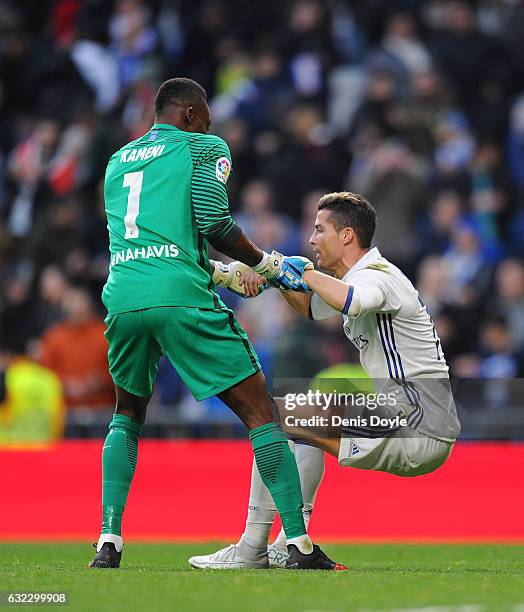 Cristiano Ronaldo of Real Madrid is helped to his feet by Carlos Idriss Kameni of Malaga CFduring the La Liga match between Real Madrid CF and Malaga...