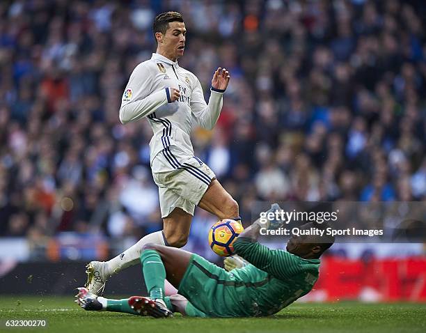 Cristiano Ronaldo of Real Madrid competes for the ball with Carlos Kameni of Malaga during the La Liga match between Real Madrid CF and Malaga CF at...