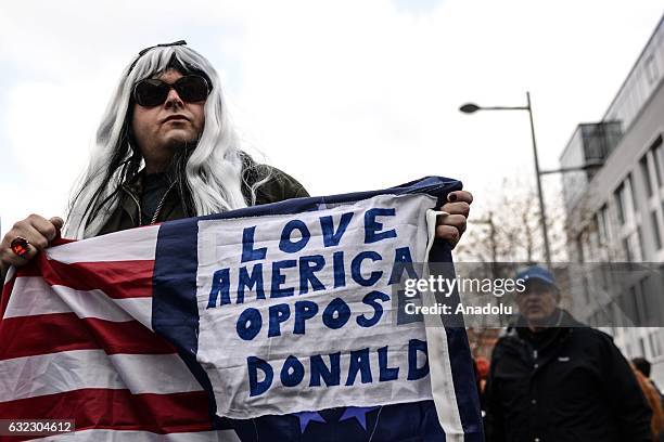 Man wears fake hair and holds placard during a protest held in solidarity with the Washington DC Women's March in Dublin, Ireland on January 21, 2017.