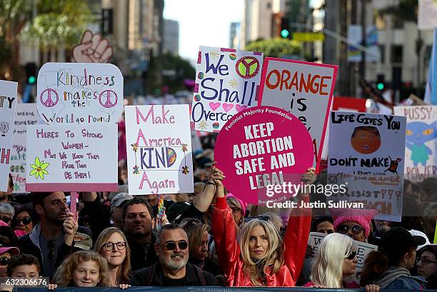 Participants hold signs as they march during the Women's March on January 21, 2017 in Los Angeles, California. Tens of thousands of people took to...
